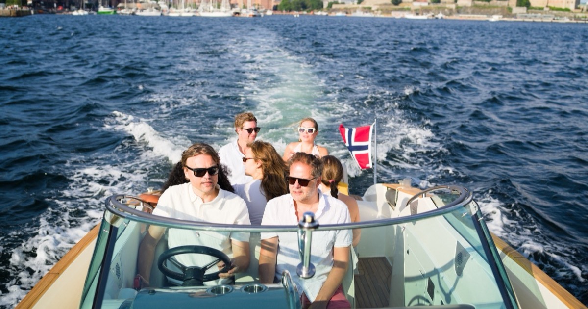 Guests on the aft deck with Oslo City Hall and Akershus Fortress on the horizon