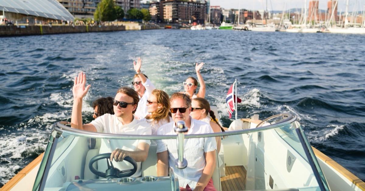 Boat heading out on the Oslofjord with the Oslo waterfront behind on a summer afternoon