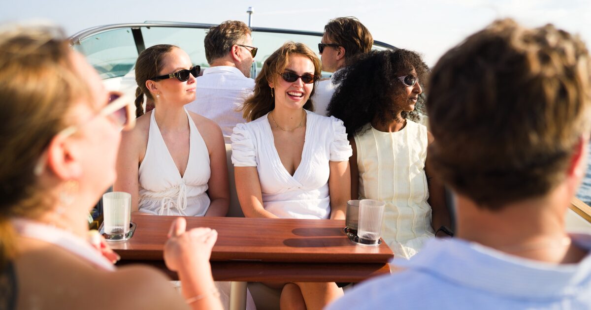 Guests laughing together around the table on board