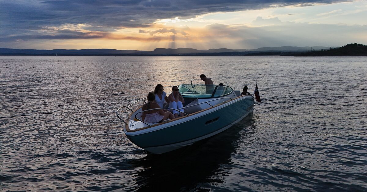 The boat cruising under heavy clouds with light breaking through