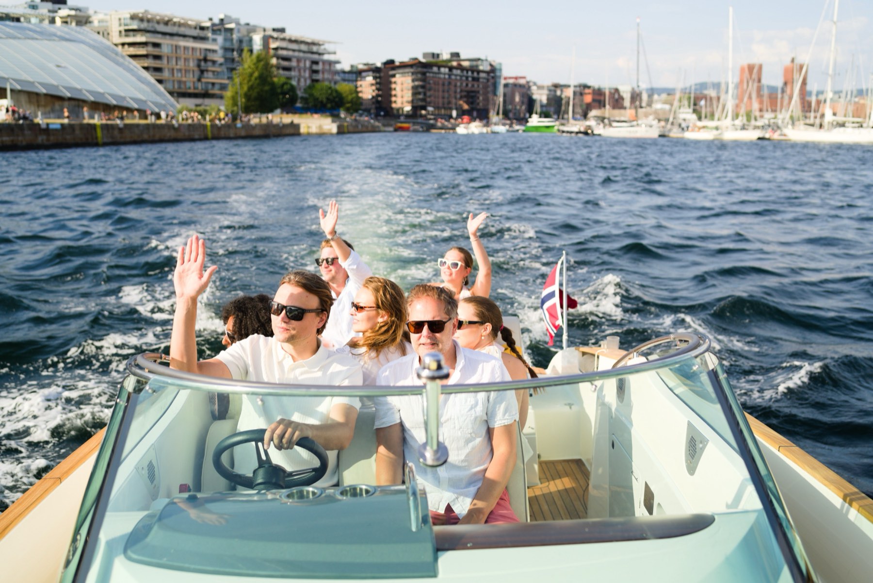 Guests on board on the Oslofjord, the city behind